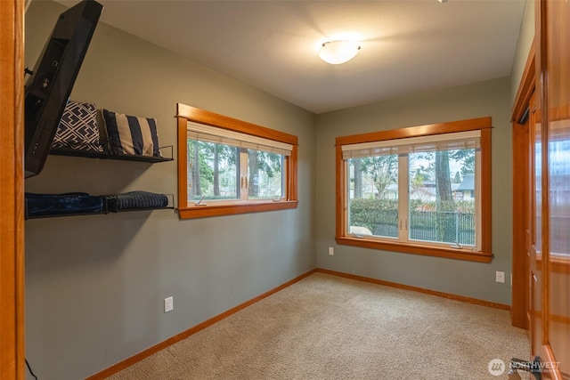 carpeted spare room featuring baseboards