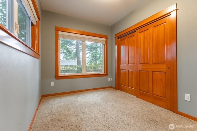 unfurnished bedroom with carpet floors, a closet, and baseboards