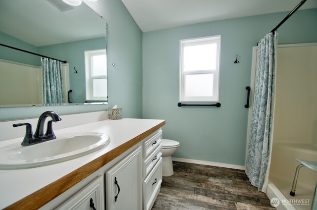 bathroom with plenty of natural light, vanity, toilet, and wood finished floors