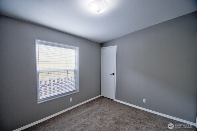 carpeted empty room with baseboards