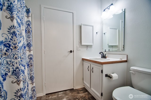 bathroom featuring wood finished floors, vanity, and toilet