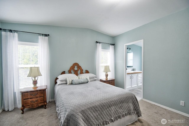 bedroom featuring baseboards, vaulted ceiling, connected bathroom, and light colored carpet