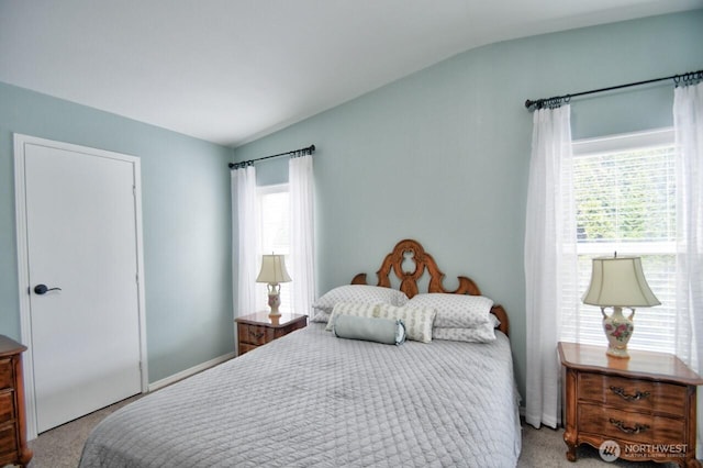 bedroom with vaulted ceiling and light colored carpet