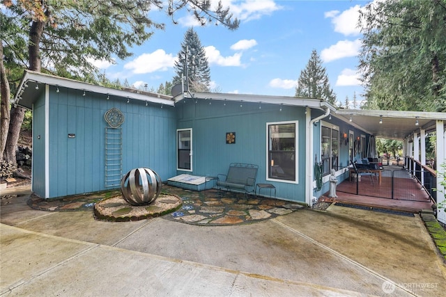 rear view of house with a patio and a wooden deck