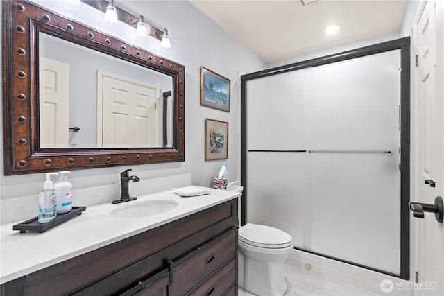 full bathroom featuring toilet, a shower stall, and vanity