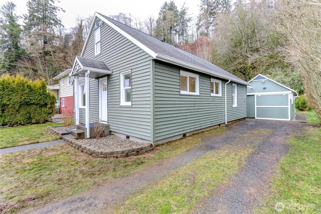 view of side of home featuring crawl space, driveway, and an outbuilding