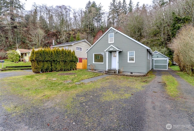 bungalow with an outbuilding, entry steps, crawl space, driveway, and a front lawn