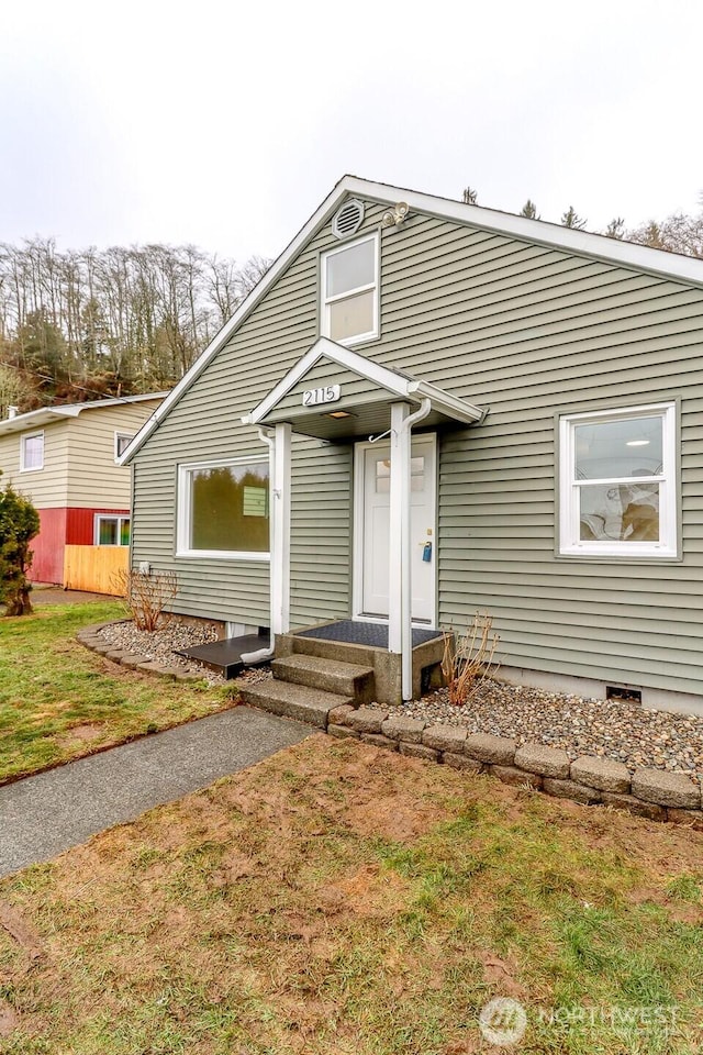 view of front of home with entry steps and a front yard