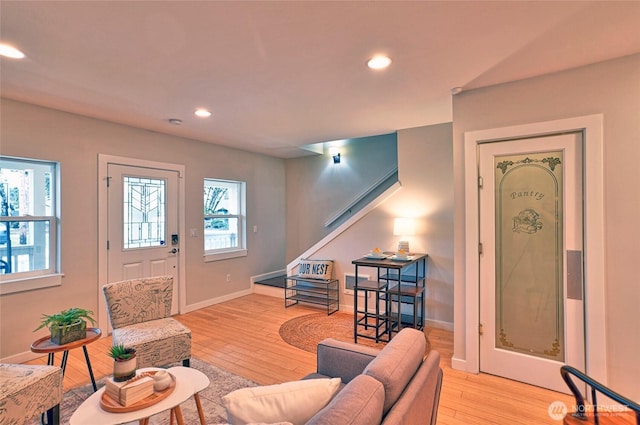 living area featuring light wood-type flooring, baseboards, and recessed lighting