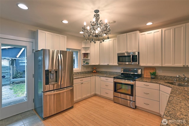 kitchen featuring white cabinetry, appliances with stainless steel finishes, open shelves, and a sink