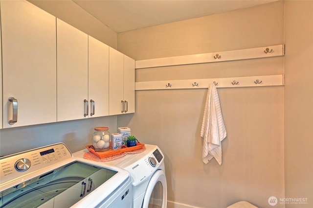 clothes washing area featuring washer and clothes dryer and cabinet space