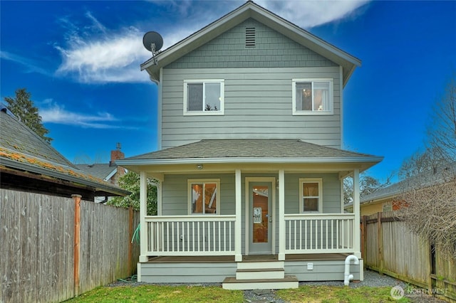 view of front of home featuring covered porch, a shingled roof, and fence