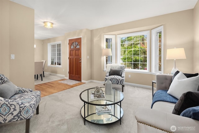 living room featuring light colored carpet, visible vents, and baseboards