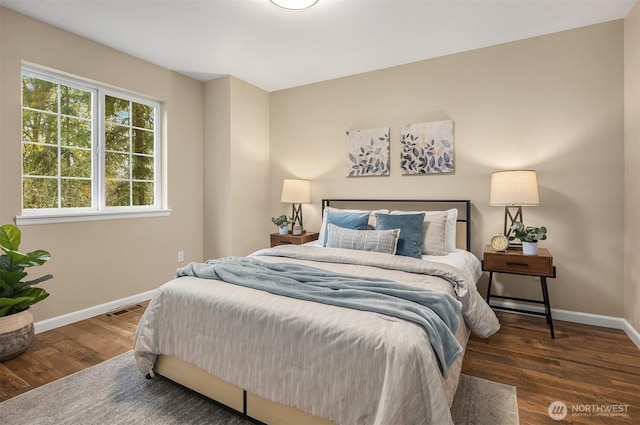 bedroom featuring dark wood-type flooring, visible vents, and baseboards