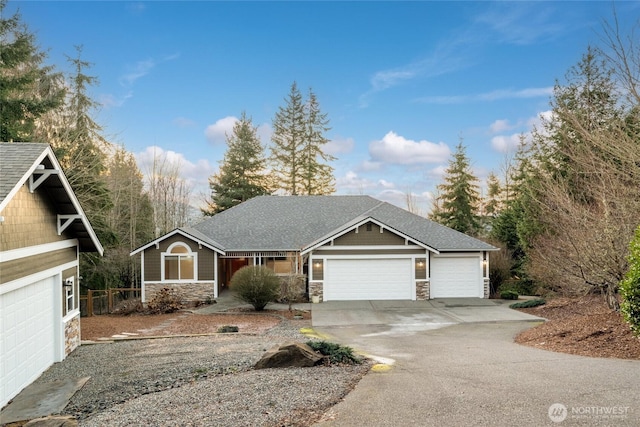 view of front of home with concrete driveway, stone siding, a shingled roof, and an attached garage