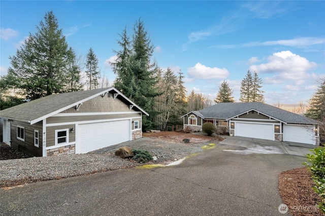 view of front facade featuring aphalt driveway, a garage, and stone siding