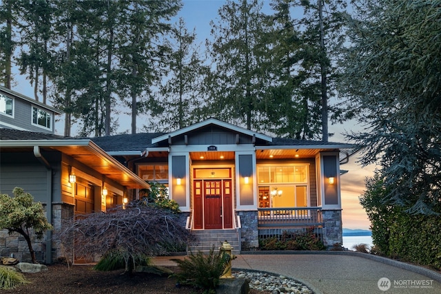 view of front of property featuring stone siding and a porch