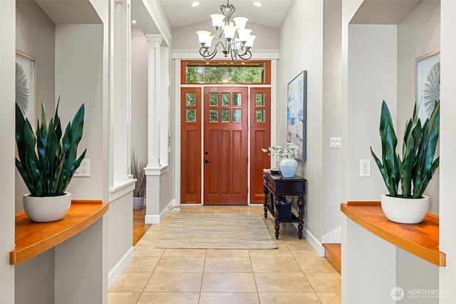 foyer with decorative columns, an inviting chandelier, light tile patterned flooring, vaulted ceiling, and baseboards