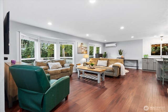 living room featuring dark wood-style floors, a wall mounted AC, baseboards, and recessed lighting