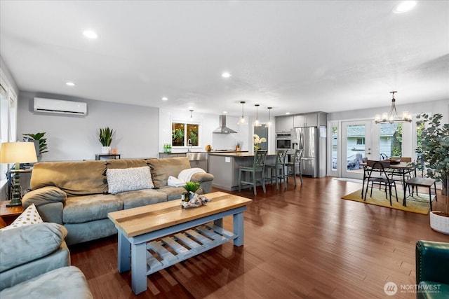 living room featuring a wealth of natural light, dark wood finished floors, an AC wall unit, and recessed lighting