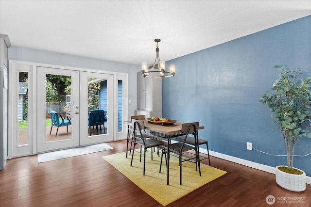 dining room featuring an inviting chandelier, baseboards, dark wood-style flooring, and french doors