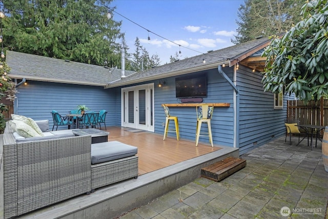 wooden terrace with outdoor dining area, outdoor lounge area, and french doors