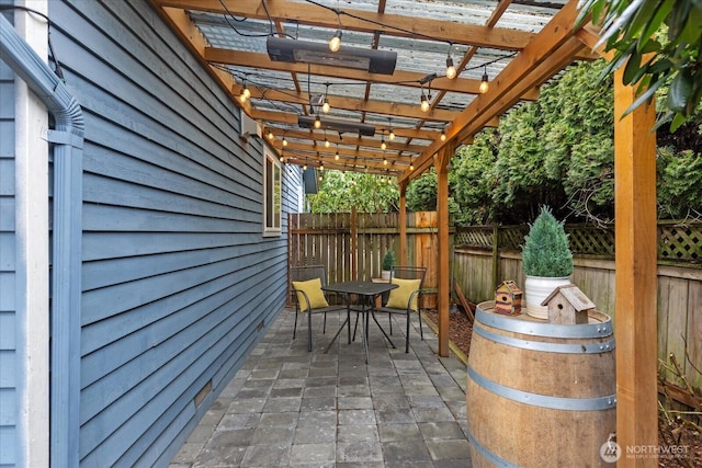 view of patio with outdoor dining space, fence, and a pergola