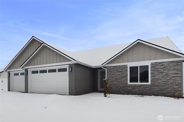 ranch-style house featuring stone siding, board and batten siding, and an attached garage