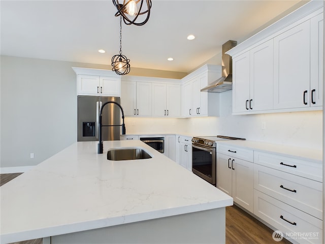 kitchen with decorative light fixtures, stainless steel appliances, white cabinetry, a sink, and wall chimney exhaust hood