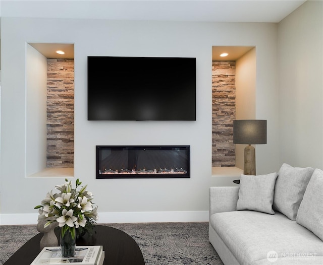 living area with a glass covered fireplace and baseboards