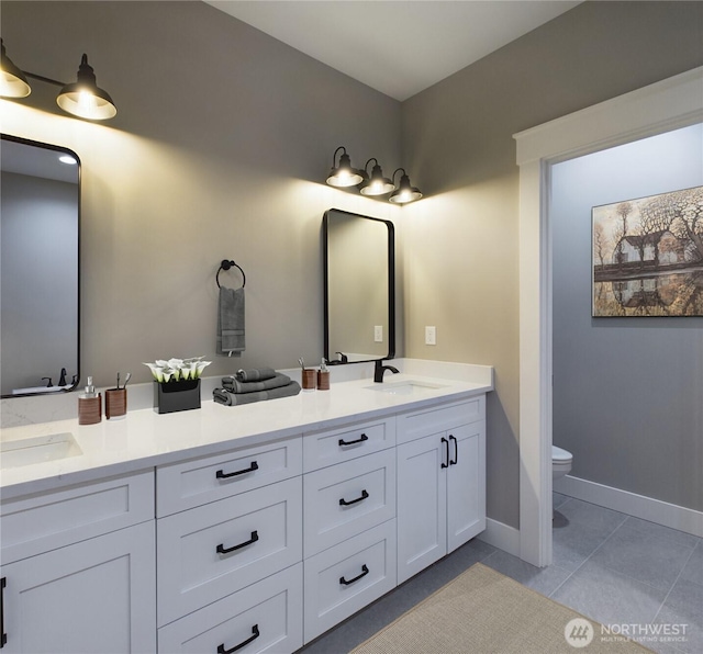 bathroom with double vanity, tile patterned flooring, toilet, and a sink