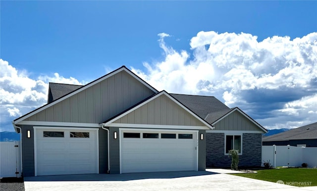 922 NE Tyler Pl E, Wenatchee, WA 98802 - view of front of house with an attached garage, fence, concrete driveway, board and batten siding, and a shingled roof