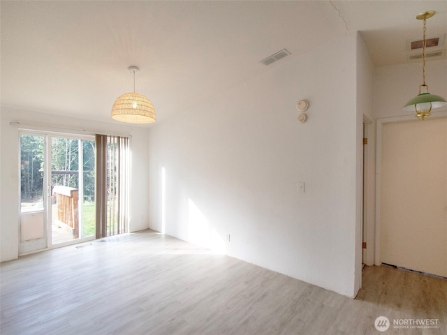 unfurnished room with visible vents and wood finished floors