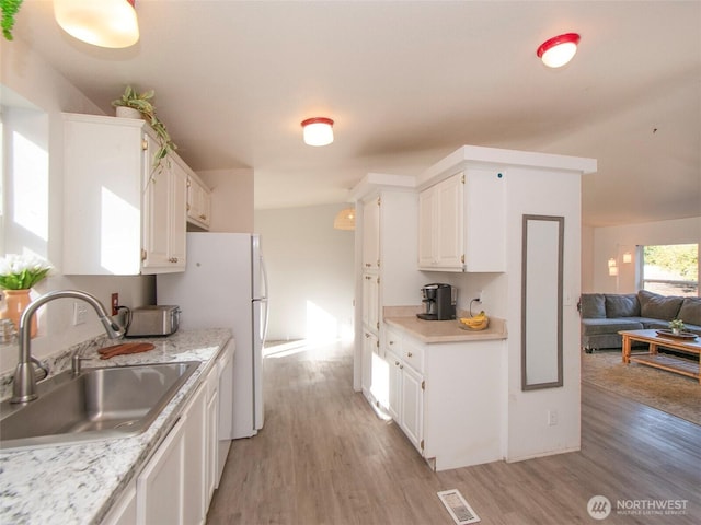 kitchen with visible vents, light countertops, and a sink