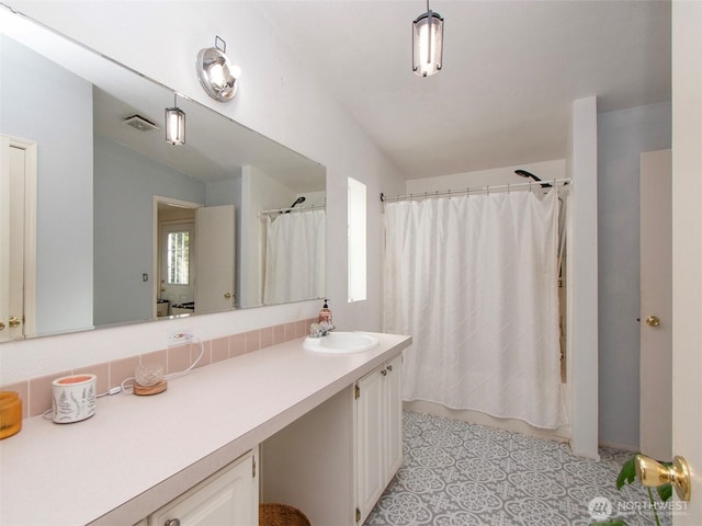 bathroom featuring visible vents, shower / tub combo with curtain, and vanity