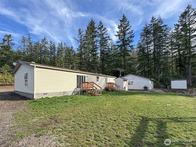 rear view of house with crawl space, an outdoor structure, a wooden deck, and a lawn