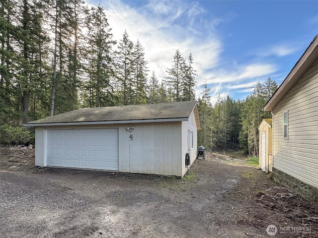 detached garage with a forest view