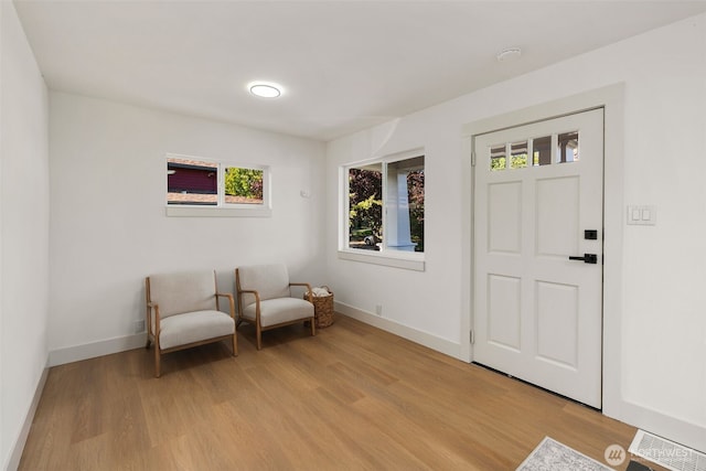 living area featuring light wood-style flooring and baseboards