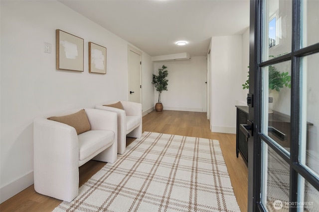 sitting room with light wood-type flooring and baseboards