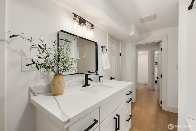 bathroom with vanity, baseboards, and wood finished floors