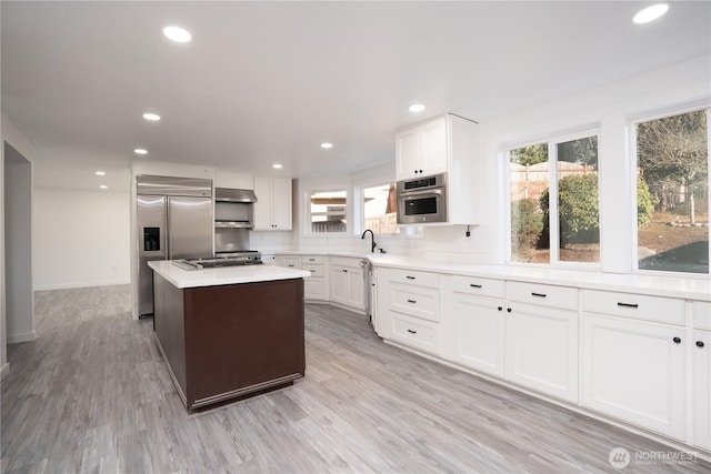 6201 53rd Street Ct W, University Place, WA 98467 - kitchen featuring ventilation hood, light wood finished floors, appliances with stainless steel finishes, and a sink