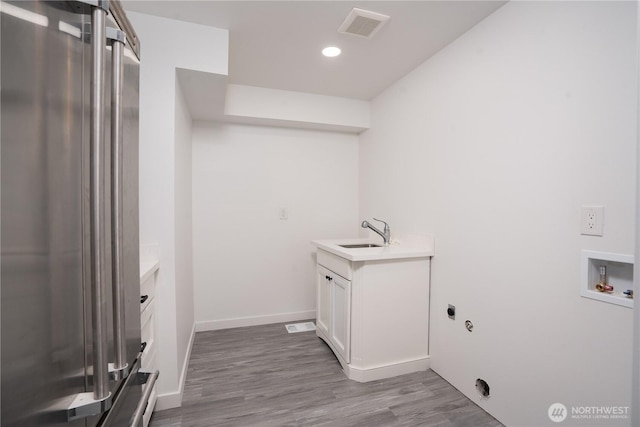 6201 53rd Street Ct W, University Place, WA 98467 - laundry room featuring visible vents, a sink, wood finished floors, hookup for a washing machine, and laundry area