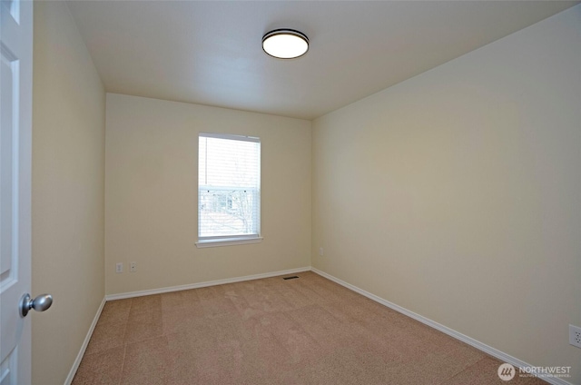 empty room featuring baseboards and light colored carpet