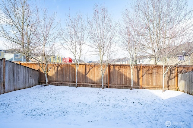 yard covered in snow featuring a fenced backyard