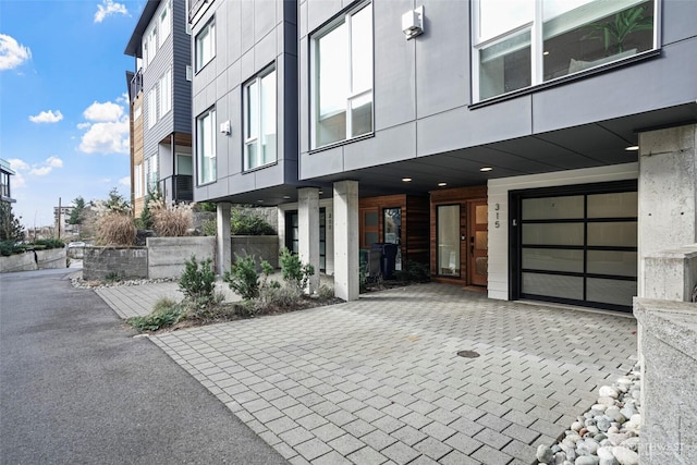 exterior space featuring a garage and decorative driveway