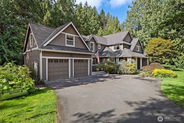 shingle-style home featuring driveway and roof with shingles