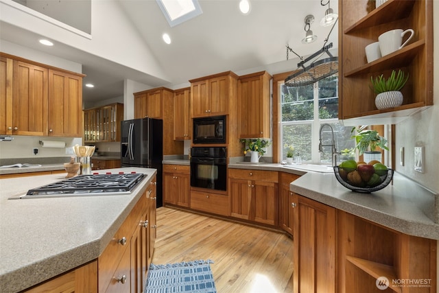 kitchen featuring light countertops, a sink, black appliances, and open shelves