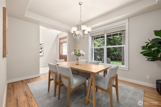 dining room featuring baseboards, a notable chandelier, and light wood-style floors