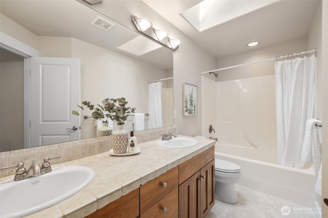 bathroom featuring a skylight, visible vents, a sink, and shower / tub combo with curtain