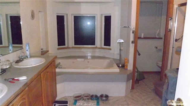 full bath with double vanity, a sink, toilet, and a bath